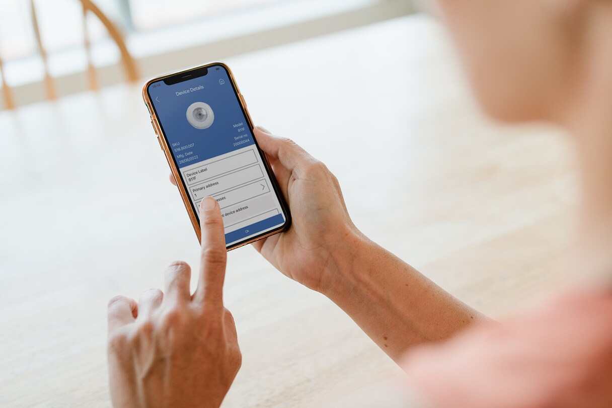 A person looking at a mobile screen displaying details of a fire detection unit